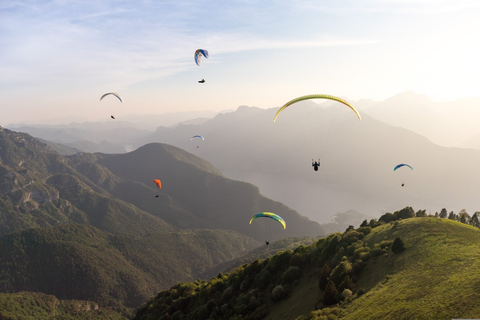 Paragliding wing in flight above a mountain landscape